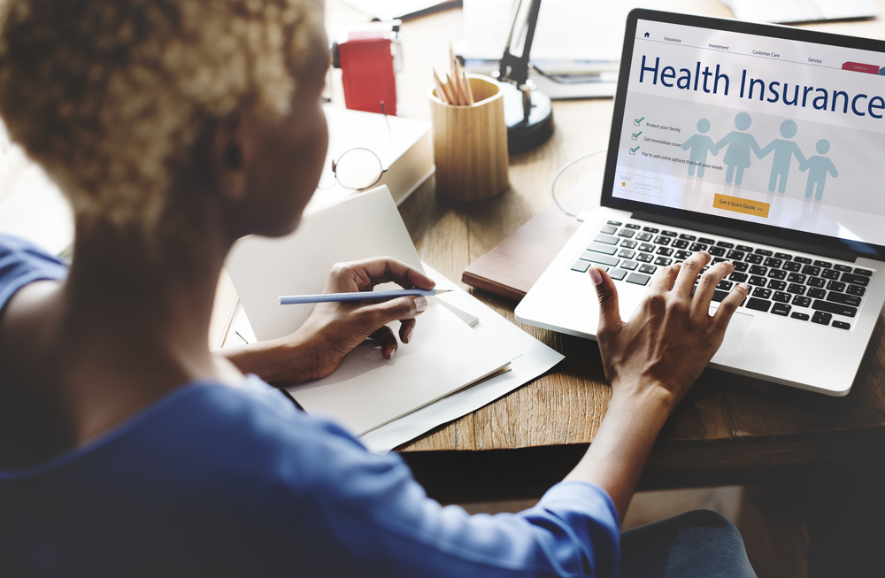 Young woman searches for health insurance online on her laptop