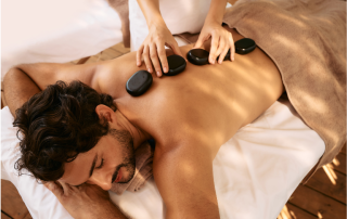 man relaxes during hot stone massage therapy