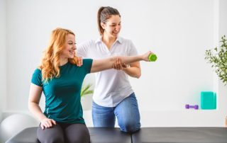 Physiotherapist assisting patient with arm strength exercise using a dumbbell during rehabilitation session
