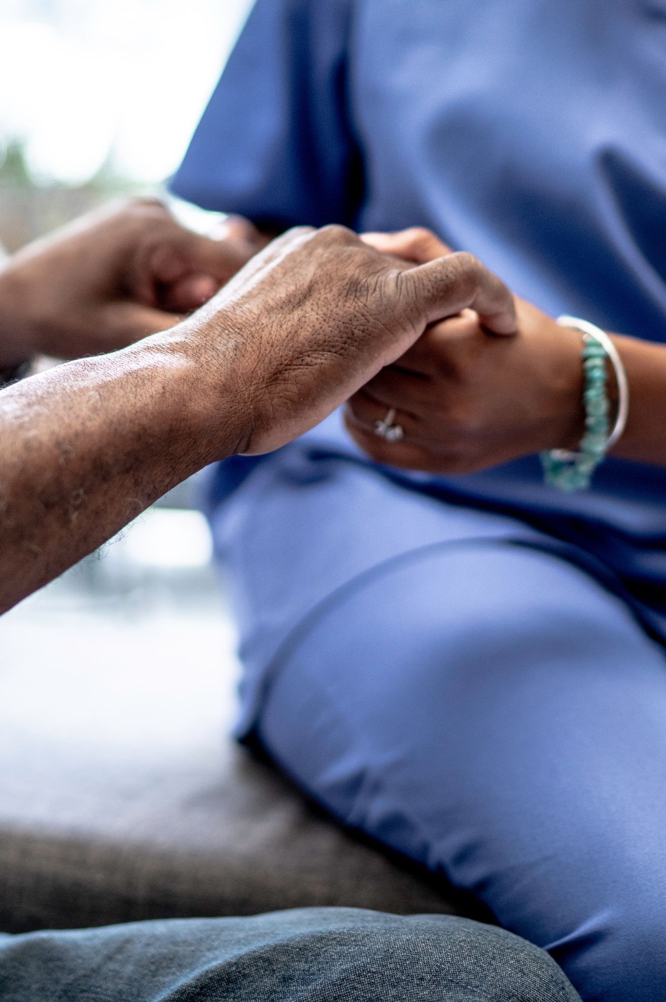 Veteran Care Smiling woman receiving shoulder physiotherapy treatment from a healthcare professional in a blue uniform.
