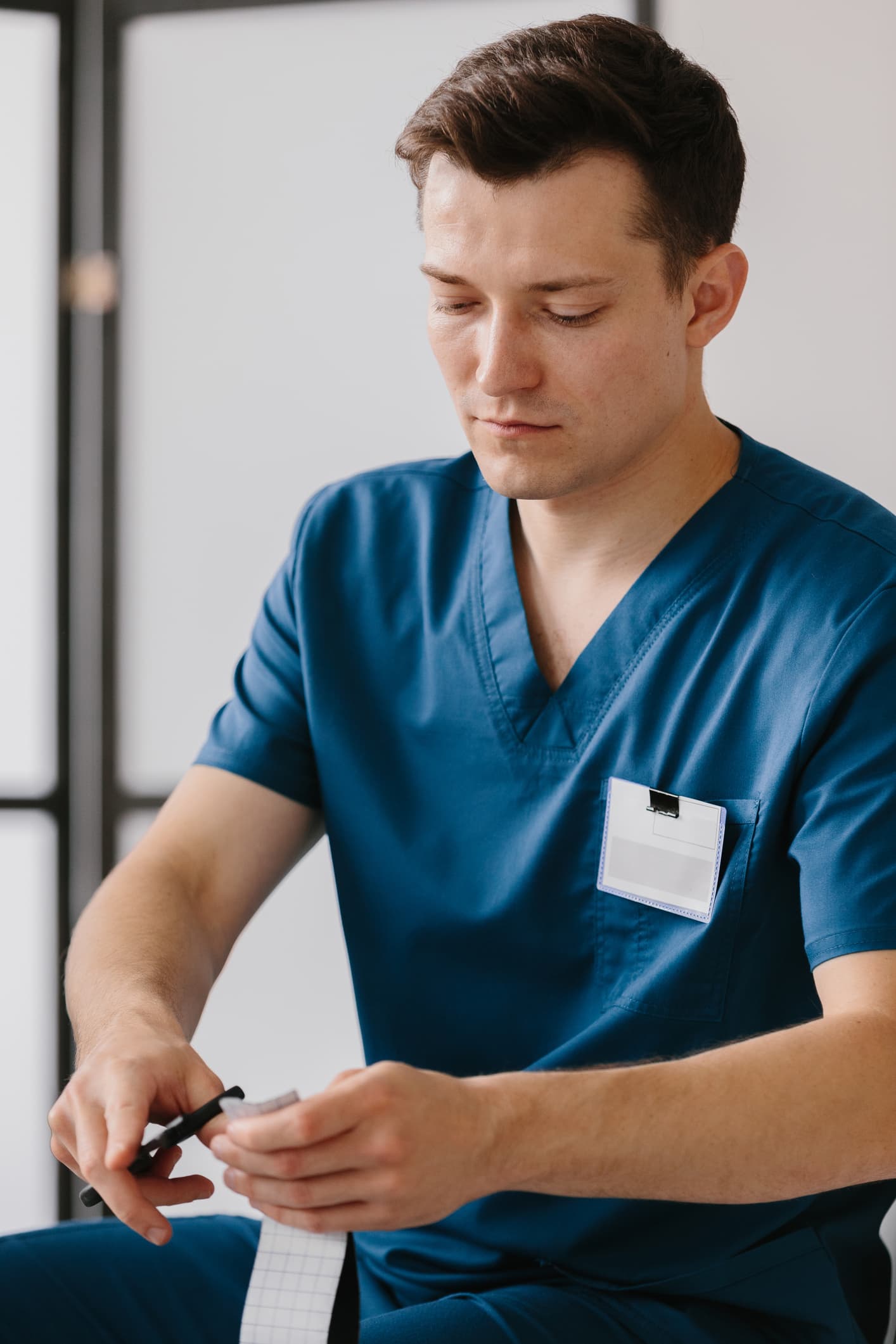 healthcare-professional-patient-assessment-notes Smiling woman receiving shoulder physiotherapy treatment from a healthcare professional in a blue uniform.