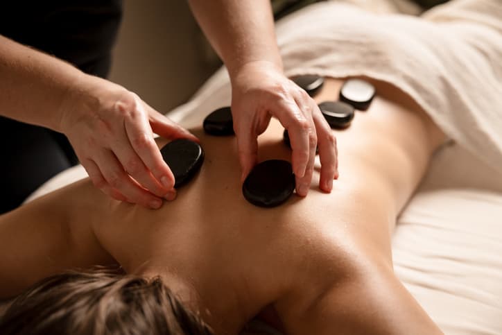 Hot Stone Massage Therapy for Relaxation and Muscle Recovery Shockwave therapy being applied to a patient's arm for muscle pain treatment