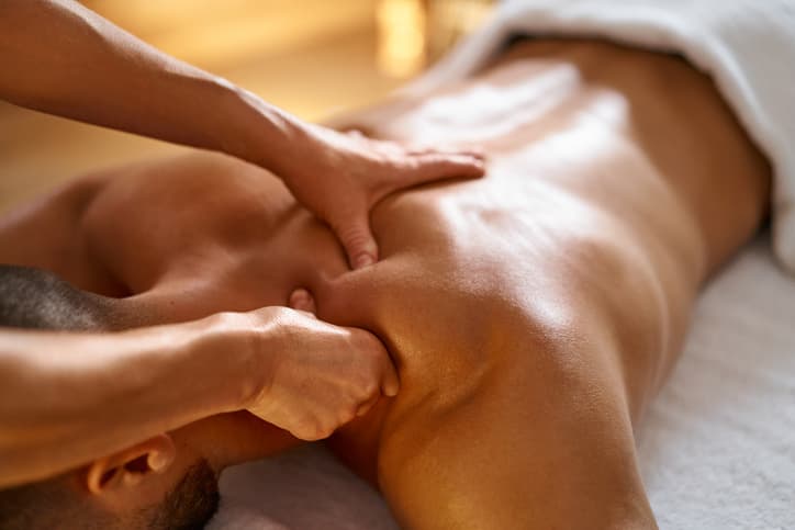 Massage Therapist Performing Deep Tissue Back Treatment Chiropractor in Edmonton performing neck adjustment on a patient in a clinic