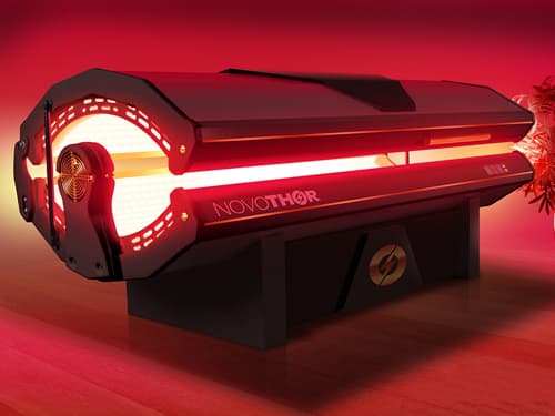 A red light therapy bed emits therapeutic red and near-infrared light during a full-body photobiomodulation session, designed to support recovery, reduce inflammation, and promote overall wellness.