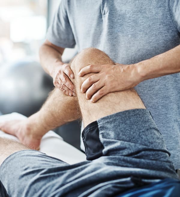 Physiotherapist Performing Knee Therapy A physiotherapist performs hands-on therapy on a patient's knee during a rehabilitation session. The image highlights physiotherapy treatment for knee pain, sports injuries, mobility improvement, and recovery from injury.