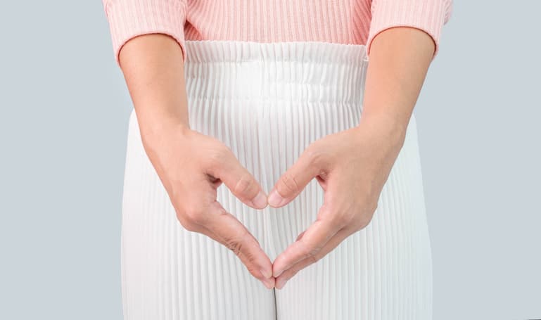 Women’s Pelvic Health Woman holding her hands in a heart shape over her pelvic area, representing pelvic health, wellness, and women’s health care.